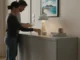 El papel de los tableros reconstituidos en la construcción ecológica Gente decorando un salón con un mueble de tableros reconstituidos